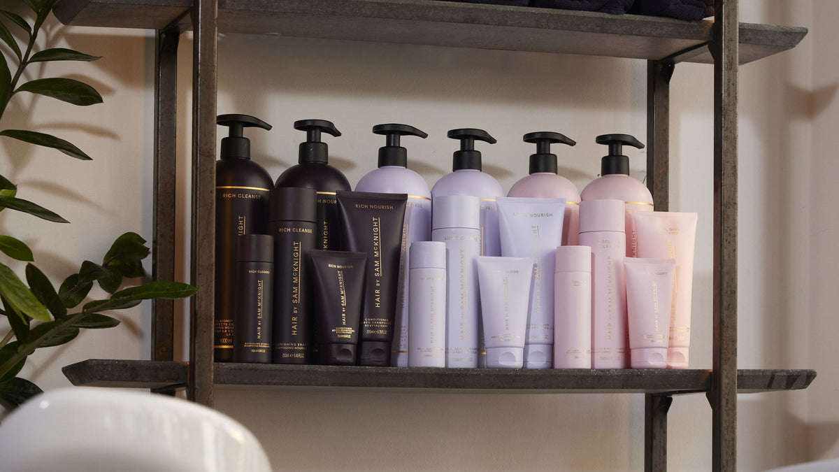 Shampoos und Conditioner von Hair by Sam McKnight in allen Größen im Regal am Waschplatz